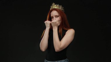 Tacıyla siyah arka plana şakayla poz veren kadın, büyüleyici ifadesi ve zarif hareketleriyle güzelliği ve güveni temsil ediyor..