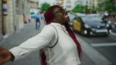 Şehir caddesinde taksiler ve arka plandaki insanlarla gülümseyen kadın, şehir dekorasyonu, çeşitli kültürleri tasvir eden ve güneşli bir günde canlı bir atmosfer..