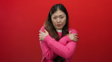 Pembe kazaklı kadın kırmızı arka planda çeşitli ifadeler sergiliyor. Soğuk ve tefekkür gibi duyguları çağrıştırıyor..