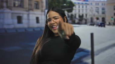 Kalabalık bir caddede şehir ortamında neşeli bir ifadeyle gezen bir kadın..