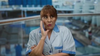 Yolcu gemisindeki temizlikçi kadın şaşırmış görünüyor. Üniformalı, açık havada, ispanyol kökenli, orta yaşlı, arka planda okyanus, kıdemli..
