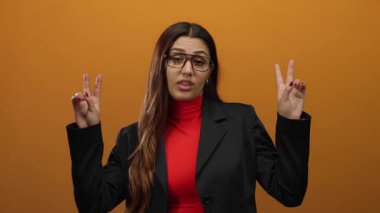Kadın, turuncu arka planda, gözlük ve kırmızı gömlek takarak, duyguları el hareketleriyle sorgulayarak, profesyonelliği ve İspanyol kimliğini somutlaştırarak şüphesini dile getiriyor..