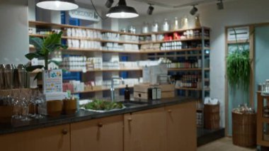 Zarif rafları olan şık bir kapalı mekan dükkanının odaklanmış görünümü çevre aydınlatması altında çeşitli dekor ve alışveriş öğeleri sergiliyor.