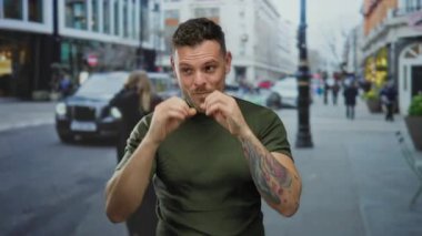 Dövmeli genç bir İspanyol, şehir sokaklarında elleri dürbünlü dürbünler kullanarak şehir ortamında neşeli ve ilginç ifadeler yakalıyor..