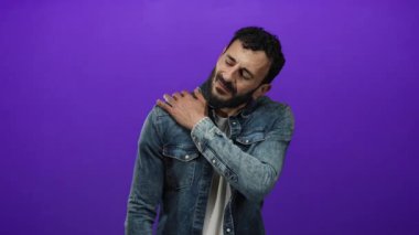 Kot ceket giyen İspanyol adam, mor arka plana dokunup rahatsızlık veriyor.