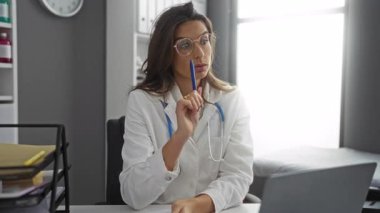 Stetoskop ve laptopla klinikteki kadın doktor danışma sırasında not alıyor..