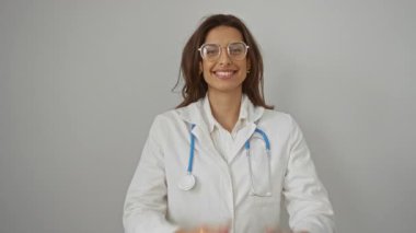Steteskoplu beyaz önlüklü gülümseyen bir kadın, tıbbi ve sağlık teması için ideal olan mutluluk ve takdiri gösteren izole edilmiş beyaz arka plan üzerinden ellerini çırpıyor..