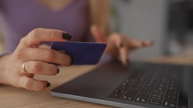 Kapalı mekanlarda dizüstü bilgisayar kullanan bir kadın, online alışveriş veya modern bir oturma odasında bankacılık öneriyor, dijital, teknoloji ve günlük yaşam tarzını vurguluyor.