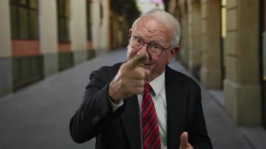 İş elbisesi giyen kıdemli bir adam, şehir caddesinde, profesyonel bir tavırla şehir yaşamını ve kendine olan güvenini dışa vuruyor..