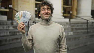 Güney Kore banknotlarını elinde tutan İspanyol bir adam, açık şehir ortamında finansal başarı ve para kavramını gözler önüne seriyor..