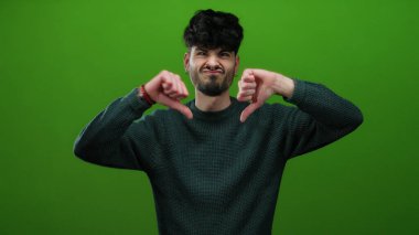 İzole edilmiş bir ortamda yeşil duvara karşı baş aşağı bir jest yaparak hoşnutsuzluğunu ifade eden adam, açıkça tasvip etmiyordu..
