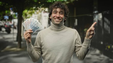 Gülümseyen bir adam, Polonya 'da finansal başarı ve kentsel yaşam tarzını olumlu ve kendinden emin bir tavırla öneren, şehir sokaklarında zloti banknotları tutuyor..