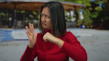 Açık hava parkı ortamında yumruklarıyla hayal kırıklığını ifade eden kadın.