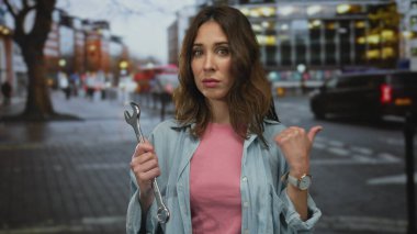 Şehrin caddesinde anahtar tutan İspanyol kadın, somut şehir ve alet odaklı tema.