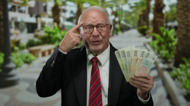 Üst düzey bir adam elinde Czech Koruna banknotları, gözlüklü ve takım elbiseli, parmaklarıyla kafaya dokunuyor, sokak düzeninde akıllı finansal tavsiyeler veriyor..