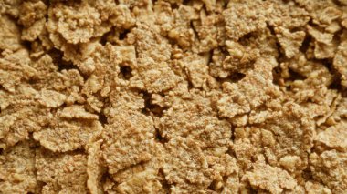 Gevrek mısır gevreğine yakın çekim, sağlıklı bir kahvaltı için mükemmel doku ve tahıl gevreğinin tanecikli ayrıntıları..