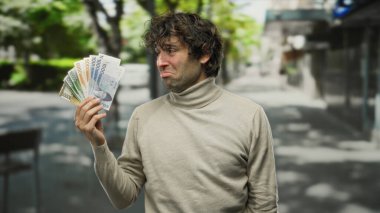 Güney Kore 'yi elinde tutan İspanyol bir adam hüzünlü bir ifadeyle kazandı. Bu da kentsel bir ortamda mali strese işaret ediyor..