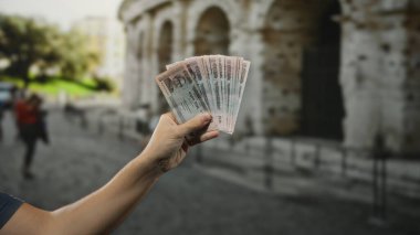Bangladeş banknotları tutan adam, Taka 'yı Roma Kolezyum Şehri' nin dışında kültürel değişim seyahatleri sergilerken gösteriyor..