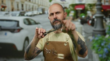 Dövmeli berber, kentin hareketli caddesinde cesurca makas yapıyor.