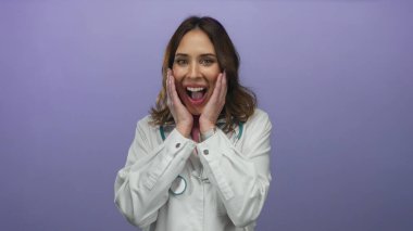 Steteskoplu genç İspanyol kadın doktor, izole edilmiş mor arka planda şaşkınlığını dile getiriyor. Tıbbi bir ortamda duygusal bir an ve bir bağlantı yakaladı..