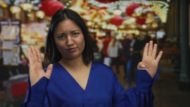 Şehir sokaklarında renkli ışıklarla dolup taşan pazarda mavi gömlekli bir kadın Çin kültürünün unsurlarını ve canlı pazar atmosferini ön plana çıkarıyor..