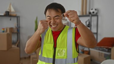 Evin anahtarlarını elinde tutan genç adam mutlu bir ifadeyle, taşınmayı ya da emlak satın almayı öneriyor.