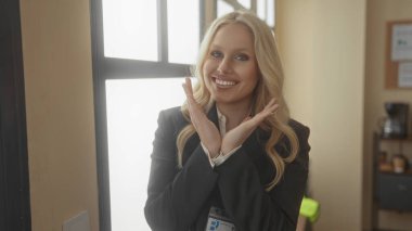 İş toplantısı sırasında pencerenin yanında rozet takan ve gülümseyen bir kadın.