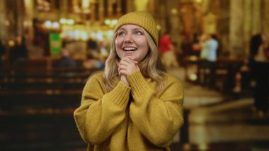 Kilisenin içinde gülümseyen sarı kazak ve şapka giyen, insanlarla çevrili sıcak ve huzurlu bir atmosferde mutluluk ve maneviyat taşıyan bir kadın..