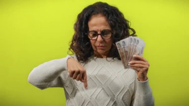 Elinde Rus rublesi tutan ve altın sarısı bir arka plana işaret eden bir kadın, mali durumdan memnun olmadığını gösteriyor..