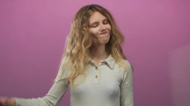 Kadın, sarışın genç bir mankenle stüdyoda pembe arka planda açıkça bir jest ve ifade sergileyen hoşnutsuz bir tavır sergiliyor..