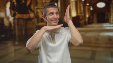 Kilisede el kol hareketleriyle gülümseyen bir adam sıcacık bir ışıkla ifadesinin gelişigüzel bir anını yakalıyor..