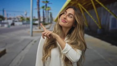 Kadın kaldırımda baş parmağını kaldırdı; onay neşe iyimserliği.