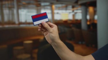 Elinde nakışlı Rusya bayrağı olan bir adam bir kahve restoranında kapalı bir yerde..