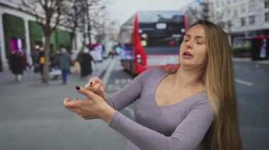 Kırmızı bir otobüsle kalabalık bir caddede hayali bir halat çeken bir kadın, şehir ortamında dinamik bir ifade sergiliyor, günlük hayatı ve eylemi canlı bir şekilde harmanlıyor..