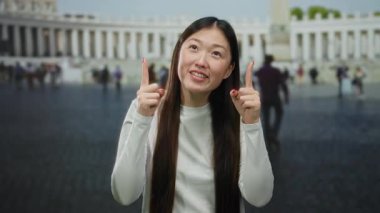 Vatikan 'ın St. Peter Meydanı' nda gülümseyen kadın, hareketli şehir manzarasının ortasında neşeli bir anı yakalıyor..