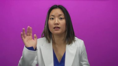 Beyaz bir ceketle canlı pembe bir arkaplan üzerinde şaşkınlık ve merakını ifade eden bir kadın canlı ve dinamik bir görsel sahne yaratıyor..