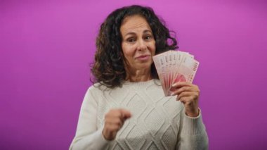 Tayvan banknotları tutan kadın mor bir duvarın üzerinde para ve finans kavramını gösteren küçük bir jest yapıyor..