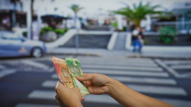 Arka planda bulanık bir şehir manzarası olan, şehir merkezinde bir sokak üzerinde el ele tutuşan Güney Afrika rand 'ı açık hava ticaretinin özünü yakalıyor..