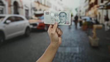 Şehir geçmişi bulanık, Singapur Doları banknotları elinde tutan adam, şehir merkezinde döviz alışverişini vurguluyor..