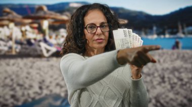 Czech banknotları elinde tutan kadın sahilde para kavramını ön plana çıkarıyor..