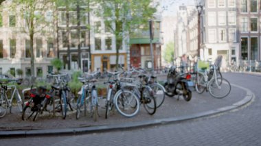 Amsterdam, Hollanda 'da odaksız mimari ve bokeh etkisine sahip bisikletlerin yer aldığı bulanık şehir manzarası, Avrupa' da tam anlamıyla kentsel bir manzara yakalıyor.