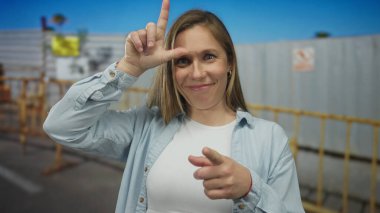 Genç kadın eli inşaatta kaybeden tabelasına imza attı; alay alay eden mizah oyunculuğu.