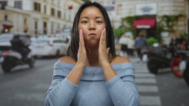 Yoğun şehir sokağında rahat bir şekilde gülümseyen bir kadın, etrafında arabalarla, günlük kıyafetleriyle, şehir hayatının özünü yakalıyor..