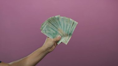 Birleşik Arap Emirlikleri 'ne bağlı beyaz bir adam pembe arkaplanlı dirhem banknotlar para ve finansmanın münferit bir temsilini sunuyor..