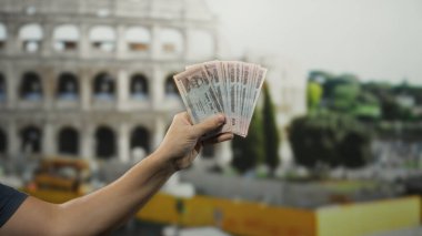Roma 'daki ikonik Roma stadyumunun önünde bangladeş banknotları tutan adam hareketli bir şehirde kültür ve para kaynağını yakalıyor..