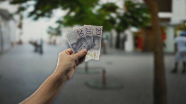 Şehir sokağında elinde İsveç kronu banknotları tutan adam. Şehir arka planı gün ışığında bulanık ve finansal konsept tasvir ediyor..