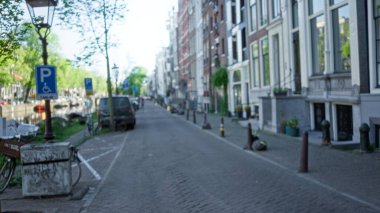 Bulanık sokak manzarası, Hollanda, Amsterdam 'da Bokeh etkisi ve sakin kentsel manzara üzerine odaklanarak büyüleyici kanallar ve klasik mimari görüntüler yakalıyor..