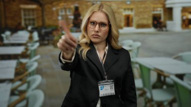 Kadınlar, restoranda elleri boş, masaları boş, iş kıyafetleri içinde gözlük takan ve kimlik kartı takan kadınlara el kol hareketi yapmazlar.