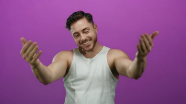 Sakallı genç bir adam beyaz bir atlet giyiyordu. Kollarını uzatarak canlı mor bir arka plana doğru gülümsüyordu. Hoş geldin enerjisi ve arkadaşlığı yakalıyordu..