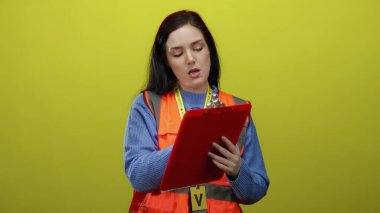 Sarı renkli, turuncu yelek giyen, panoya notlar yazan gönüllü bir kadın..